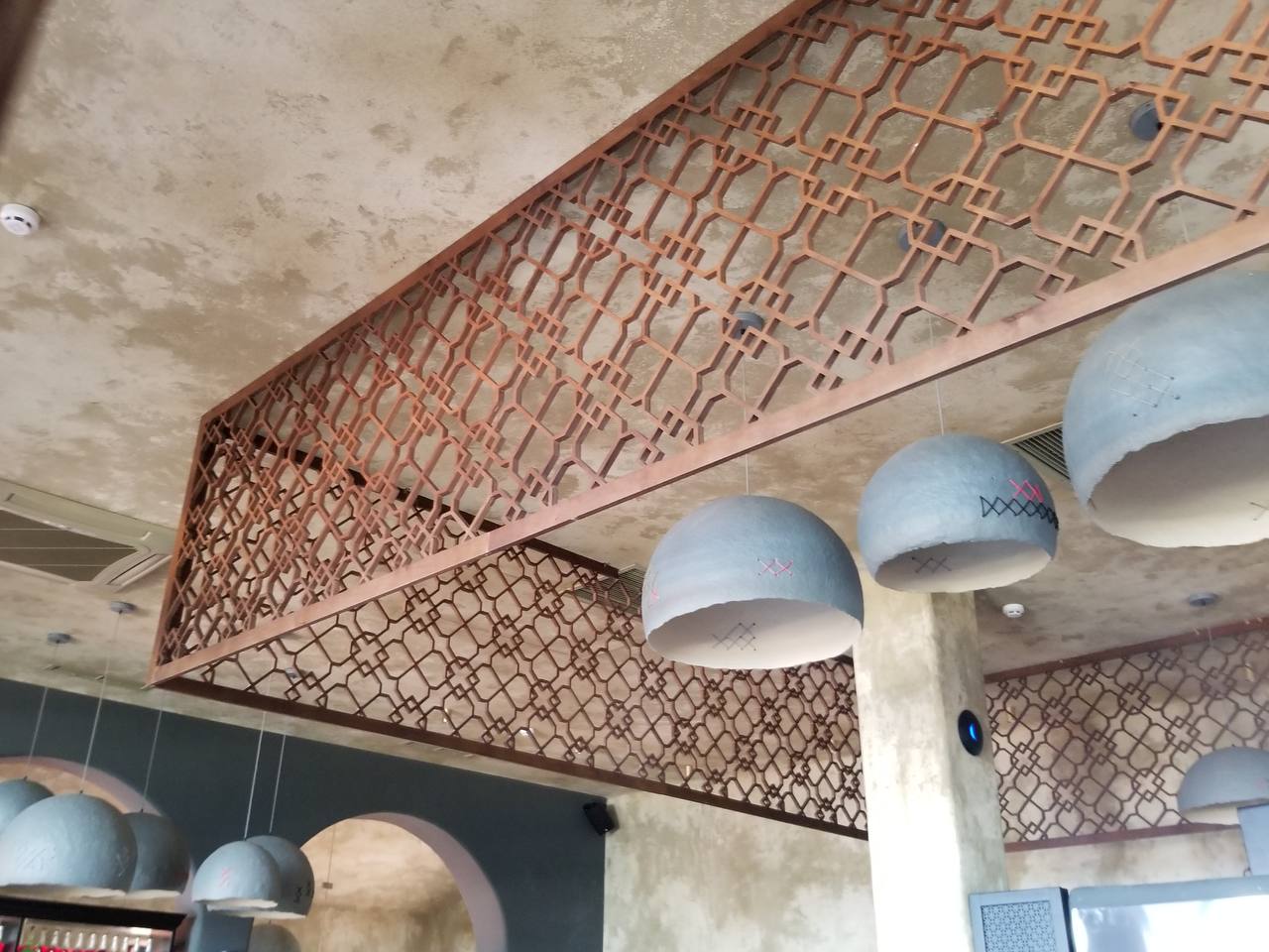 Katossa olevat koristeelliset paneelit geometrisilla ornamenteilla, valmistettu CNC-jyrsinnällä.
